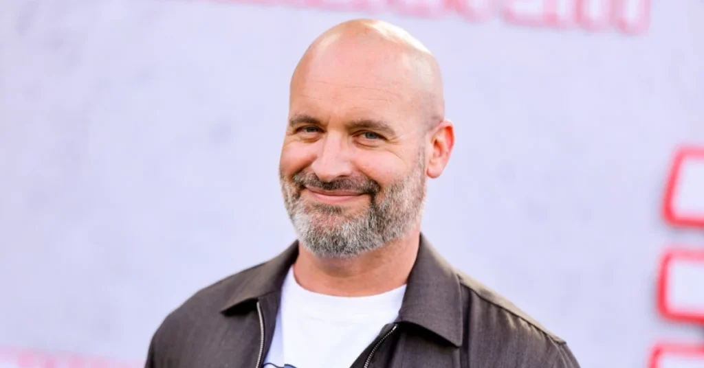 Tom Segura smiling at a media event - the successful comedian's net worth has grown to $14 million through his diverse entertainment ventures