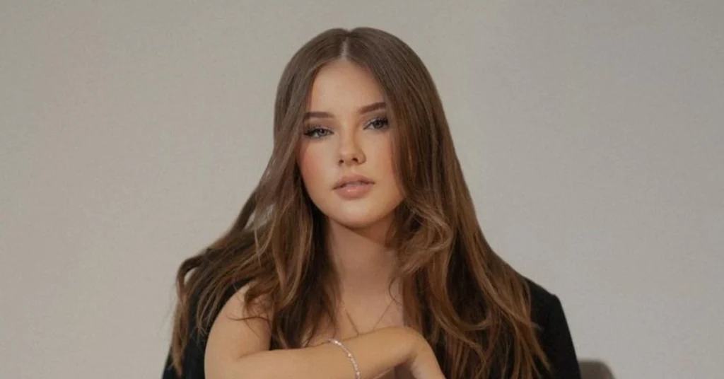 Daneliya Tuleshova Net Worth—portrait of the young singer with long brown hair in a black outfit, representing her success and career growth.
