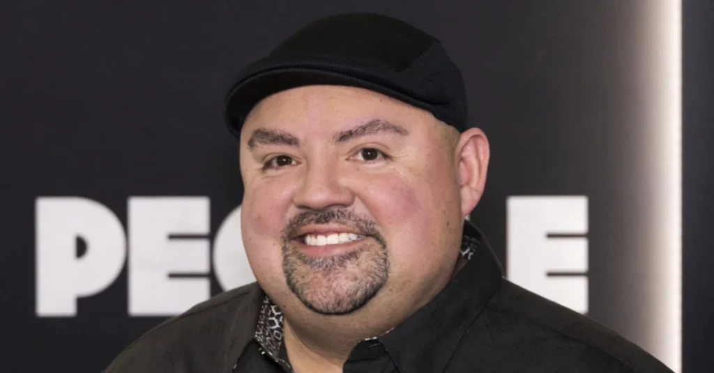 Gabriel Iglesias smiling at media event wearing his signature black cap, showcasing the charismatic personality that built his $40 million comedy empire